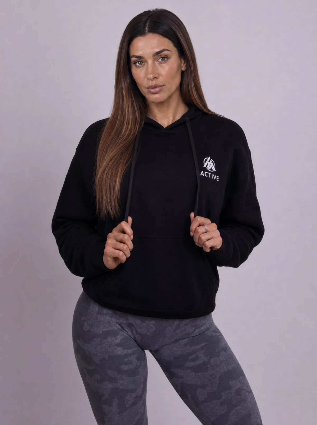 Woman wearing Keep Pushing black emblem hoodie and seamless leggings